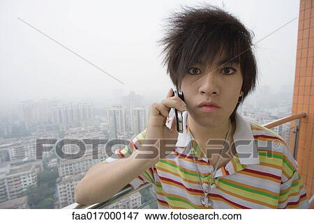 Young man using cell phone View Large Photo Image Stock Photo - Young man using cell phone. Fotosearch