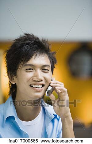 Stock Photography - Young man using cell phone. Fotosearch
