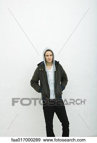 Stock Photo - Young man wearing hood, portrait. Fotosearch