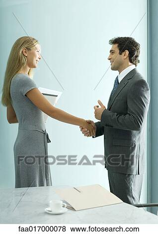 Stock Photo - Young woman and businessman shaking hands. Fotosearch