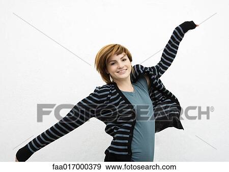 Young woman dancing around, smiling at camera, portrait View Large Photo Image Stock Photo - Young woman dancing around, smiling at camera, portrait. Fotosearch