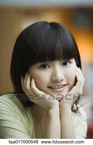 Young woman holding head in hands View Large Photo Image Stock Photo - Young woman holding head in hands. Fotosearch
