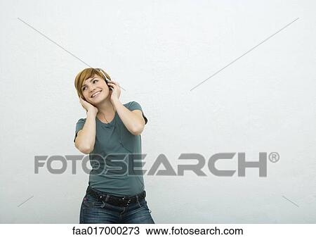 Young woman listening to headphones View Large Photo Image Stock Image - Young woman listening to headphones. Fotosearch