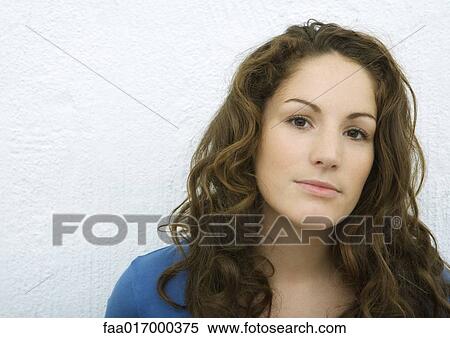 Stock Photography - Young woman looking at camera, portrait, white background. Fotosearch