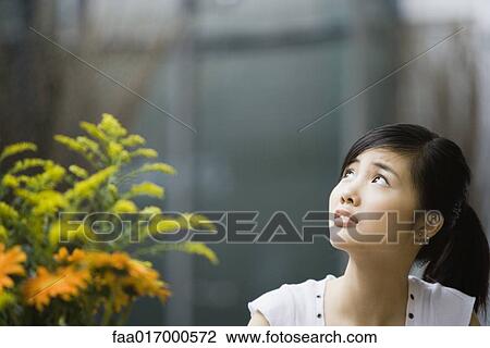Young woman looking up and raising eyebrows View Large Photo Image Stock Image - Young woman looking up and raising eyebrows. Fotosearch