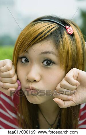 Young woman making face, looking at camera View Large Photo Image Stock Photo - Young woman making face, looking at camera. Fotosearch