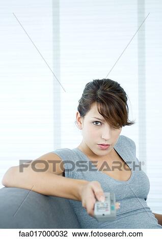 Young woman pointing remote control, looking at camera View Large Photo Image Stock Image - Young woman pointing remote control, looking at camera. Fotosearch