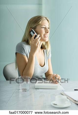 Young woman sitting with pen and pad of paper, making phone call View Large Photo Image Stock Photo - Young woman sitting with pen and pad of paper, making phone call. Fotosearch