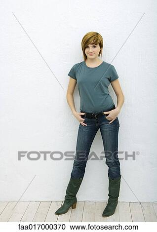 Young woman standing with hands in pockets, full length portrait View Large Photo Image Stock Image - Young woman standing with hands in pockets, full length portrait. Fotosearch