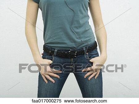 Young woman standing with thumbs in jean pockets, close-up of mid section View Large Photo Image Stock Photography - Young woman standing with thumbs in jean pockets, close-up of mid section. Fotosearch