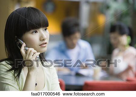 Stock Photograph - Young woman using cell phone. Fotosearch