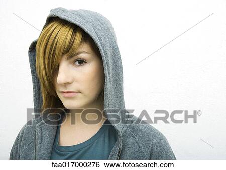 Stock Photograph - Young woman wearing hood, looking at camera, portrait. Fotosearch