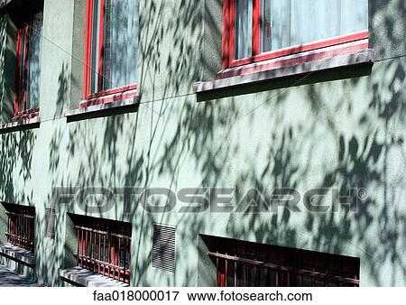 Apartment building with shadows of vegetation on facade, close-up View Large Photo Image Stock Photo - Apartment building with shadows of vegetation on facade, close-up. Fotosearch