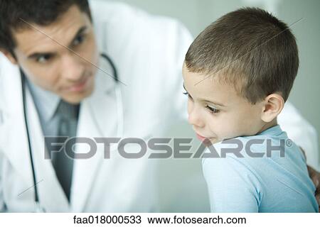 Stock Image - Boy and doctor, boy looking away. Fotosearch