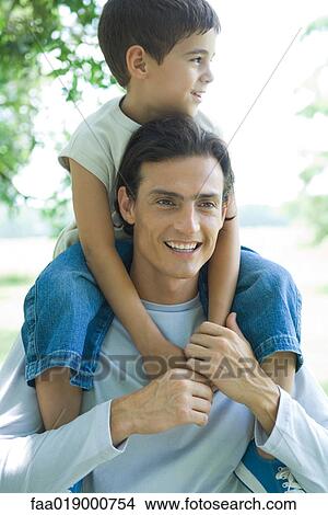 Boy and father, boy riding on man's shoulders View Large Photo Image Picture - Boy and father, boy riding on man's shoulders. Fotosearch