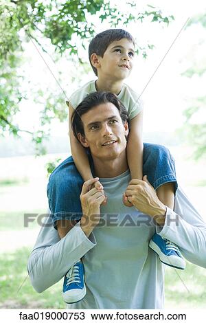 Boy and father, boy riding on man's shoulders View Large Photo Image Stock Image - Boy and father, boy riding on man's shoulders. Fotosearch