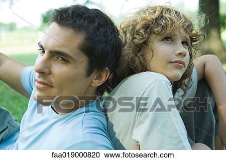 Boy and father sitting back to back View Large Photo Image Stock Image - Boy and father sitting back to back. Fotosearch