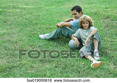 Boy and father sitting back to back View Large Photo Image Stock Photo - Boy and father sitting back to back. Fotosearch