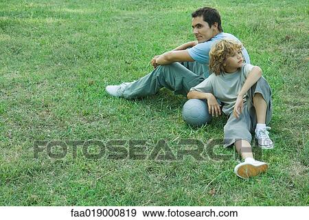 Stock Photo - Boy and father sitting back to back. Fotosearch