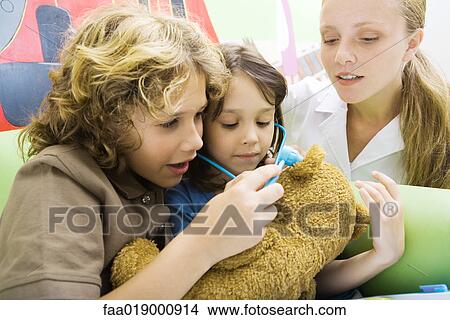 Boy and girl playing doctor with teddy bear View Large Photo Image Picture - Boy and girl playing doctor with teddy bear. Fotosearch