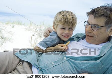 Stock Photo - Boy and grandfather on beach. Fotosearch