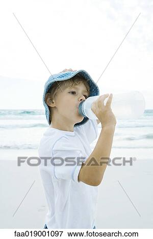 Boy drinking water on beach View Large Photo Image Stock Photo - Boy drinking water on beach. Fotosearch