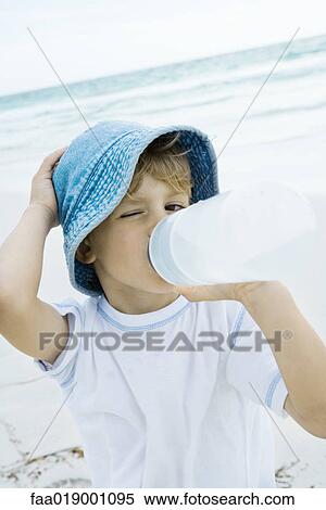Boy drinking water on beach View Large Photo Image Stock Photography - Boy drinking water on beach. Fotosearch
