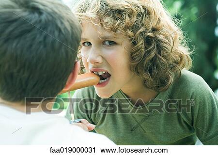 Boy eating hotdog from stake View Large Photo Image Stock Image - Boy eating hotdog from stake. Fotosearch