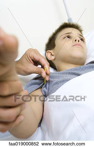 Stock Image - Boy having temperature taken. Fotosearch