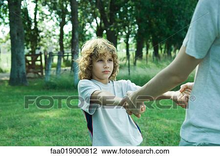 Boy holding hands with mother, partial view View Large Photo Image Stock Image - Boy holding hands with mother, partial view. Fotosearch