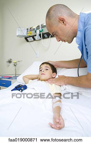 Boy lying in hospital bed, doctor taking pulse View Large Photo Image Stock Image - Boy lying in hospital bed, doctor taking pulse. Fotosearch