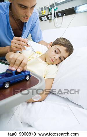 Boy lying in hospital bed, eating meal View Large Photo Image Stock Photo - Boy lying in hospital bed, eating meal. Fotosearch