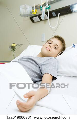 Stock Image - Boy lying in hospital bed. Fotosearch
