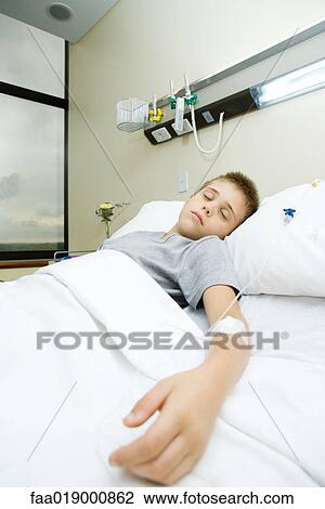 Stock Image - Boy lying in hospital bed. Fotosearch