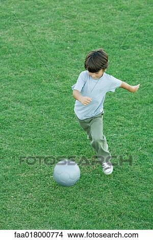 Boy playing soccer on grass, high angle view, full length View Large Photo Image Picture - Boy playing soccer on grass, high angle view, full length. Fotosearch