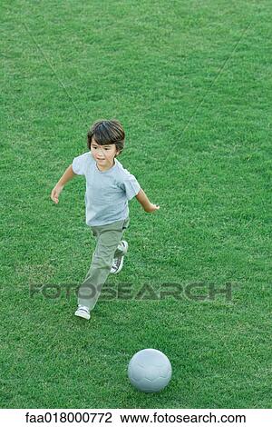 Boy playing soccer on grass, high angle view, full length View Large Photo Image Stock Image - Boy playing soccer on grass, high angle view, full length. Fotosearch