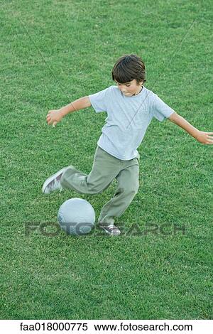 Boy playing soccer on grass, high angle view, full length View Large Photo Image Stock Photography - Boy playing soccer on grass, high angle view, full length. Fotosearch