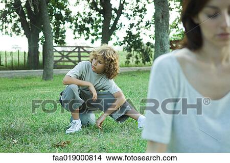 Picture - Boy sitting on ball, mother in foreground. Fotosearch