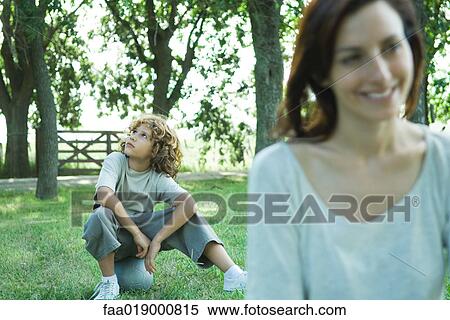 Boy sitting on ball, mother in foreground View Large Photo Image Stock Photography - Boy sitting on ball, mother in foreground. Fotosearch