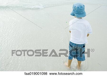Boy standing on beach View Large Photo Image Stock Photo - Boy standing on beach. Fotosearch