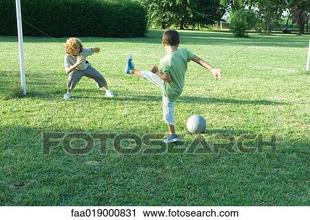 Stock Image - Boys playing soccer. Fotosearch