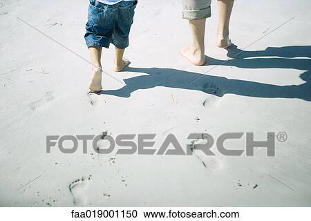 Child and adult walking on sand, low section View Large Photo Image Stock Image - Child and adult walking on sand, low section. Fotosearch