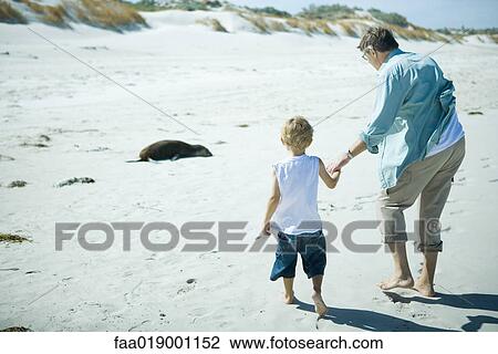 Child and adult walking on sand View Large Photo Image Stock Image - Child and adult walking on sand. Fotosearch