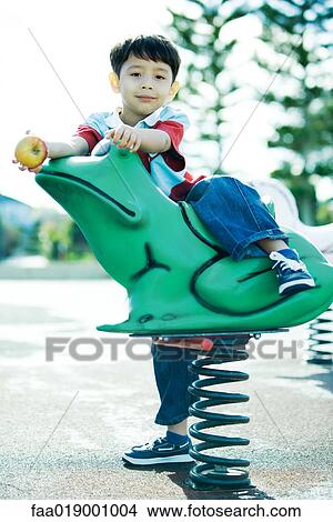 Picture - Child on playground equipment. Fotosearch