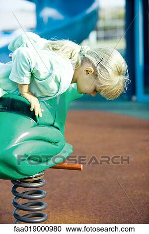 Stock Image - Child on playground equipment. Fotosearch