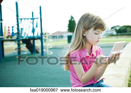 Child on playground, playing video game View Large Photo Image Stock Photo - Child on playground, playing video game. Fotosearch