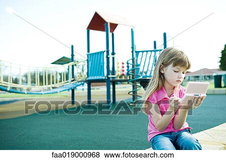 Child on playground, playing video game View Large Photo Image Stock Photo - Child on playground, playing video game. Fotosearch