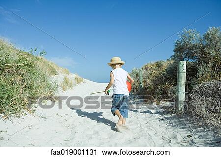 Stock Image - Child walking through dunes. Fotosearch