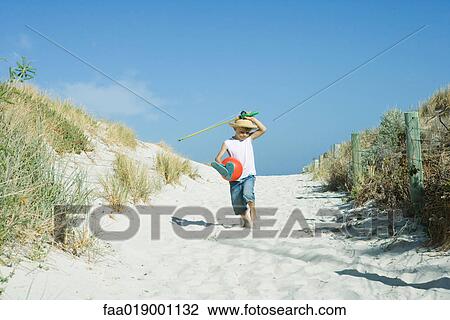 Stock Image - Child walking through dunes. Fotosearch