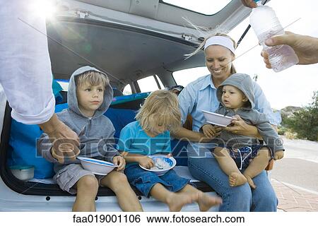 Stock Photograph - Children eating meal in back of car. Fotosearch